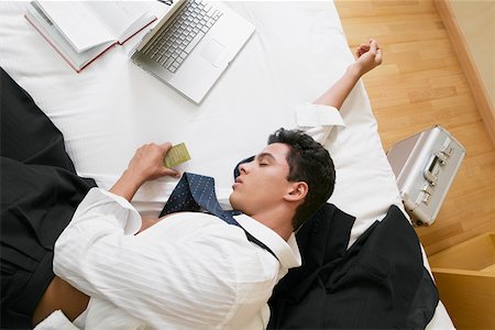 High angle view of a businessman sleeping on the bed Stock Photo - Premium Royalty-Free, Code: 625-01264527