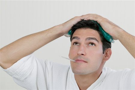 simsearch:693-07456416,k - Close-up of a young man with an ice pack on his head and a thermometer in his mouth Foto de stock - Sin royalties Premium, Código: 625-01264680