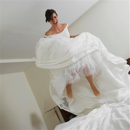 Low angle view of a bride jumping on the bed Stock Photo - Premium Royalty-Free, Code: 625-01264776