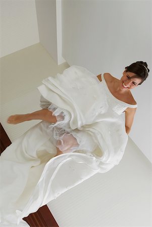 Low angle view of a bride jumping on the bed Stock Photo - Premium Royalty-Free, Code: 625-01260620