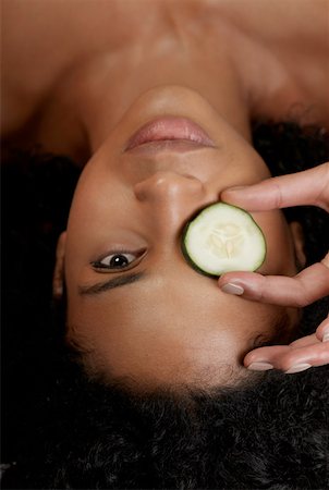 Close-up of a young woman with a cucumber slice on her eye Stock Photo - Premium Royalty-Free, Code: 625-01260680