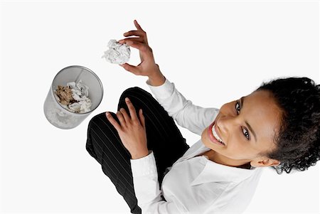 High angle view of a businesswoman throwing a crumpled sheet of paper into a wastepaper basket Stock Photo - Premium Royalty-Free, Code: 625-01260803