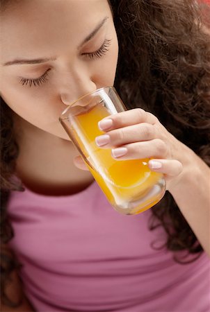 High angle view of a young woman drinking a glass of juice Stock Photo - Premium Royalty-Free, Code: 625-01261243