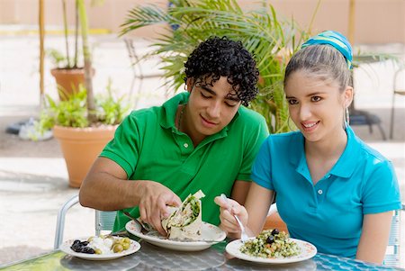 simsearch:625-00902698,k - Close-up of a teenage girl and a young man eating salad and a wrap in a restaurant Foto de stock - Sin royalties Premium, Código: 625-01261357