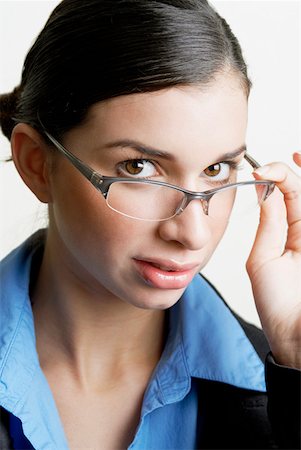 simsearch:625-01097830,k - Portrait of a businesswoman peeking over her eyeglasses Stock Photo - Premium Royalty-Free, Code: 625-01262491