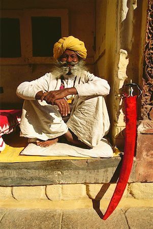 Portrait of a senior man sitting at a veranda of a museum, Meherangarh Museum, Jodhpur, Rajasthan, India Stock Photo - Premium Royalty-Free, Code: 625-01262537