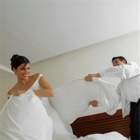 simsearch:625-00839074,k - Newlywed couple having a pillow fight on the bed Stock Photo - Premium Royalty-Free, Code: 625-01263048