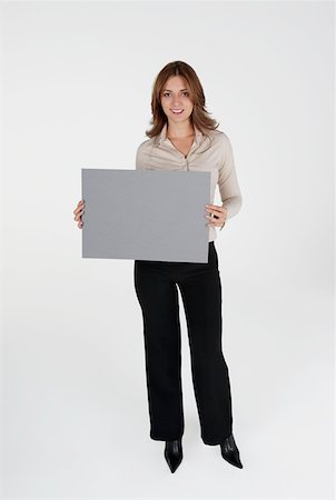 simsearch:625-01097830,k - Portrait of a businesswoman holding a placard and smiling Stock Photo - Premium Royalty-Free, Code: 625-01263617