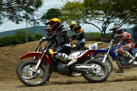 Three motocross riders riding motorcycles on a dirt road Stock Photo - Premium Royalty-Free, Code: 625-01744314