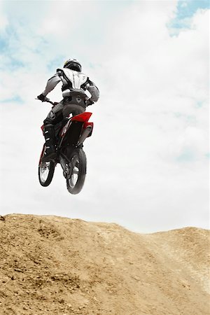Low angle view of a motocross rider performing a jump on a motorcycle Stock Photo - Premium Royalty-Free, Code: 625-01744328