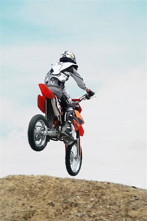 Low angle view of a motocross rider performing a jump on a motorcycle Stock Photo - Premium Royalty-Free, Code: 625-01744333