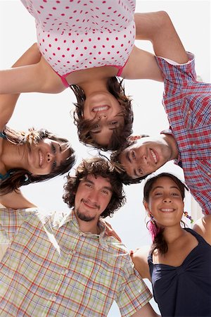 Low angle view of three young women and two young men in a huddle Stock Photo - Premium Royalty-Free, Code: 625-01746739