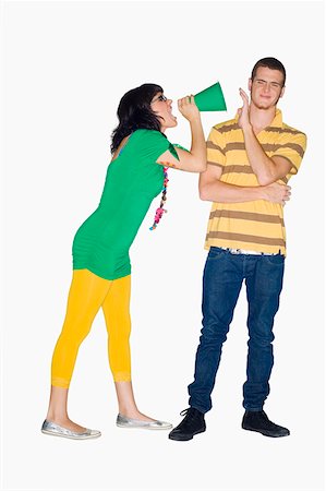 Young woman shouting with a megaphone into a young man's ear Stock Photo - Premium Royalty-Free, Code: 625-01746885