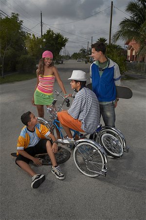Teenage boy on a low rider bicycle with his three friends beside him Stock Photo - Premium Royalty-Free, Code: 625-01746904