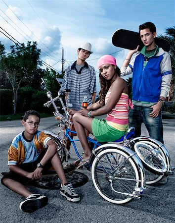 Portrait d'une jeune femme sur une bicyclette low rider avec ses trois amis à ses côtés Photographie de stock - Premium Libres de Droits, Code: 625-01747225
