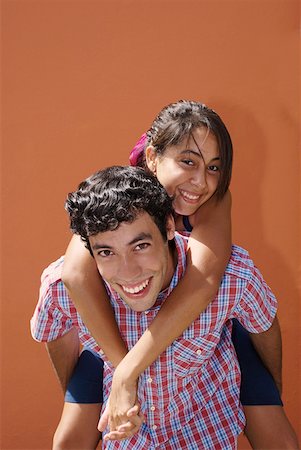 simsearch:625-00839074,k - Portrait of a young woman riding piggyback on a young man Stock Photo - Premium Royalty-Free, Code: 625-01747680