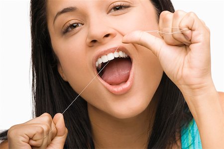 dental floss - Portrait of a young woman flossing her teeth Stock Photo - Premium Royalty-Free, Code: 625-01747850