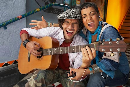 Close-up of a young man singing with a young woman and playing a guitar Stock Photo - Premium Royalty-Free, Code: 625-01747852
