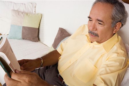 simsearch:625-02268087,k - High angle view of a senior man sitting on a couch and holding a book Foto de stock - Sin royalties Premium, Código: 625-01747908