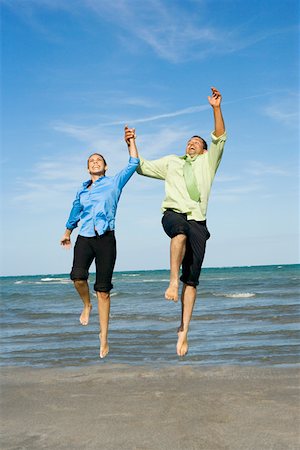 Mid adult couple jumping with holding each other hands on the beach Stock Photo - Premium Royalty-Free, Code: 625-01748048