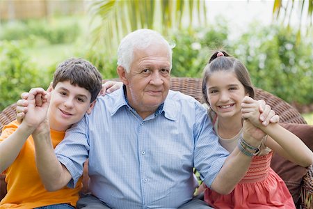 Portrait of a senior man holding his grandchildren's hands and smiling Stock Photo - Premium Royalty-Free, Code: 625-01748167