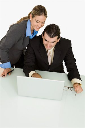Businessman and a businesswoman using a laptop and smiling Stock Photo - Premium Royalty-Free, Code: 625-01748440