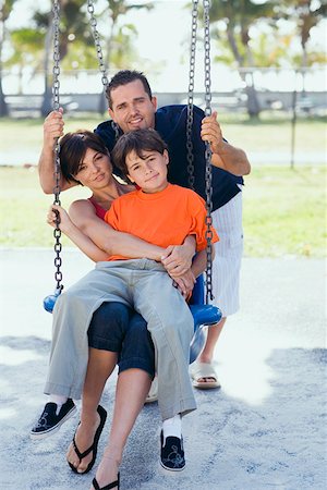 simsearch:695-05769087,k - Mid adult woman sitting on a swing with her son and a mid adult man pushing them Stock Photo - Premium Royalty-Free, Code: 625-01748704