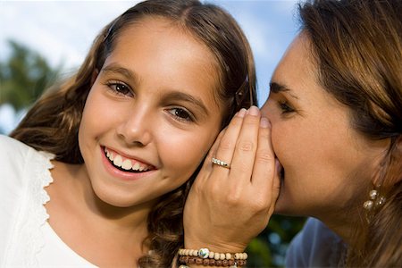 pictures of a little girl whispering - Close-up of a mid adult woman whispering into her daughter's ear Stock Photo - Premium Royalty-Free, Code: 625-01748722