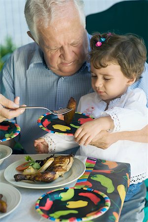 farming generation photography - Senior man feeding his granddaughter with a fork Stock Photo - Premium Royalty-Free, Code: 625-01748790