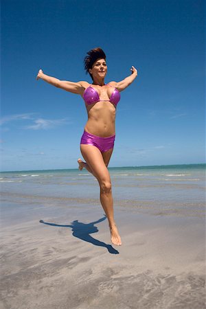 pictures of woman running with short hair - Mid adult woman running on the beach with her arms outstretched Stock Photo - Premium Royalty-Free, Code: 625-01748904