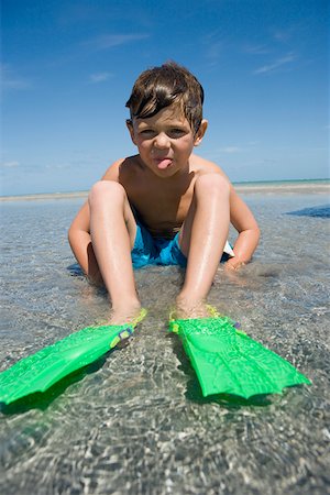 simsearch:625-01748893,k - Portrait of a boy wearing flippers and sticking his tongue out Stock Photo - Premium Royalty-Free, Code: 625-01748908