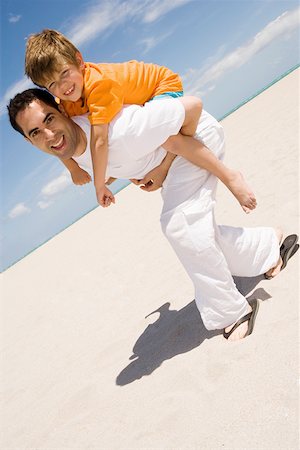 simsearch:625-01748893,k - Portrait of a boy riding piggyback on his father on the beach Stock Photo - Premium Royalty-Free, Code: 625-01748909
