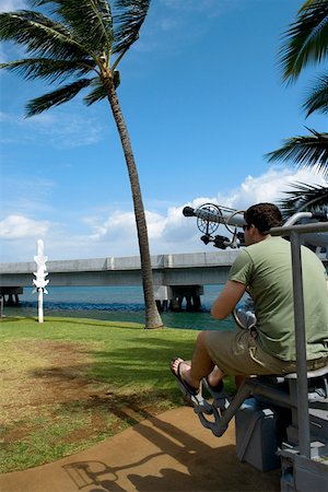 Rear view of a man sitting on an artillery cannon, Pearl Harbor, Honolulu, Oahu, Hawaii Islands, USA Stock Photo - Premium Royalty-Free, Code: 625-01751068