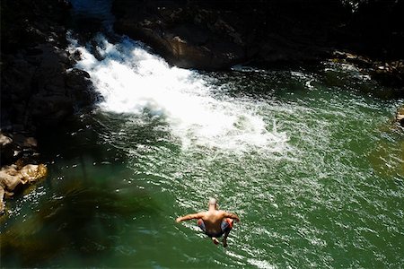 High angle view of a man jumping into a river, Onemea Bay, Big Island, Hawaii Islands, USA Stock Photo - Premium Royalty-Free, Code: 625-01751124