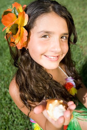 Portrait of a girl holding a conch shell and smiling Stock Photo - Premium Royalty-Free, Code: 625-01751207