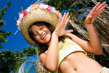 Portrait of a girl hula dancing and smiling Stock Photo - Premium Royalty-Free, Code: 625-01751246