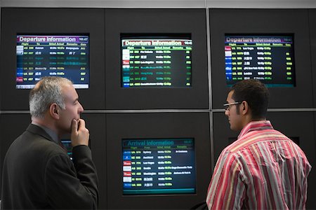 simsearch:625-02931717,k - Two businessmen looking at an arrival departure board at an airport Stock Photo - Premium Royalty-Free, Code: 625-02266471