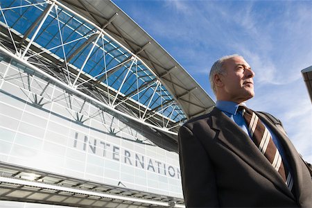 simsearch:625-02931717,k - Low angle view of a businessman standing outside an airport building Stock Photo - Premium Royalty-Free, Code: 625-02266512