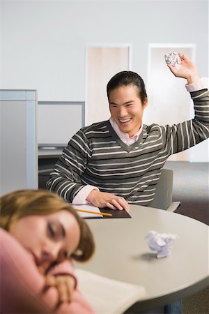 sleeping student in class room images - Close-up of a young woman napping and a young man throwing a crumpled paper on her Stock Photo - Premium Royalty-Free, Code: 625-02266537