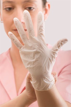 simsearch:625-02929180,k - Female nurse putting on a surgical glove Stock Photo - Premium Royalty-Free, Code: 625-02266538