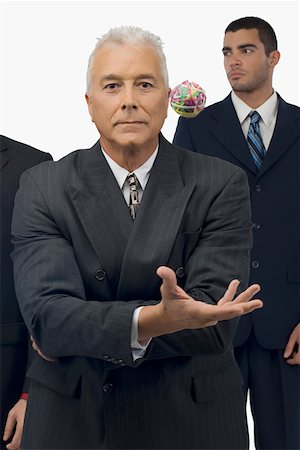 simsearch:625-02268087,k - Businessman catching a rubber band ball with two businessmen standing behind him Foto de stock - Sin royalties Premium, Código: 625-02266650
