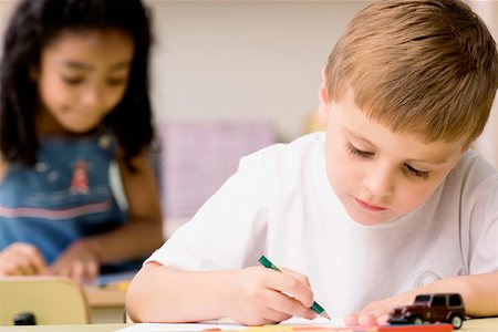 simsearch:695-05770150,k - Close-up of a boy drawing on a sheet of paper with a girl sitting behind him Foto de stock - Sin royalties Premium, Código: 625-02266716