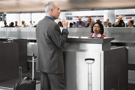 simsearch:625-02268087,k - Side profile of a businessman standing at a ticket counter in an airport Foto de stock - Sin royalties Premium, Código: 625-02266912