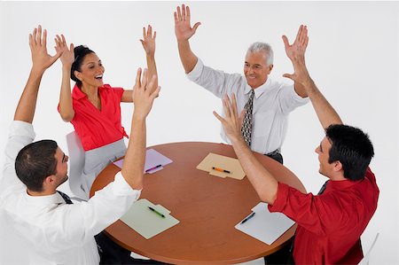 simsearch:625-02931717,k - Three businessmen and a businesswoman smiling with their arms raised in a meeting Stock Photo - Premium Royalty-Free, Code: 625-02266976