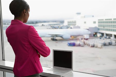 Vue arrière d'une femme d'affaires avec un ordinateur portable dans un aéroport Photographie de stock - Premium Libres de Droits, Code: 625-02267035