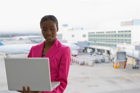 Close-up of a businesswoman using a laptop at an airport Stock Photo - Premium Royalty-Free, Code: 625-02267064