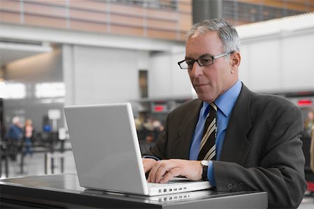 simsearch:625-02931717,k - Businessman using a laptop at an airport Stock Photo - Premium Royalty-Free, Code: 625-02267063
