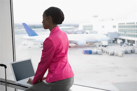 Profil de côté d'une femme d'affaires à l'aide d'un ordinateur portable dans un aéroport Photographie de stock - Premium Libres de Droits, Code: 625-02267116