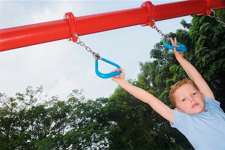 Portrait of a boy hanging on monkey bars Stock Photo - Premium Royalty-Free, Code: 625-02267207