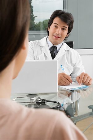 physician consulting backview - Male doctor sitting with a patient in a clinic Stock Photo - Premium Royalty-Free, Code: 625-02267287